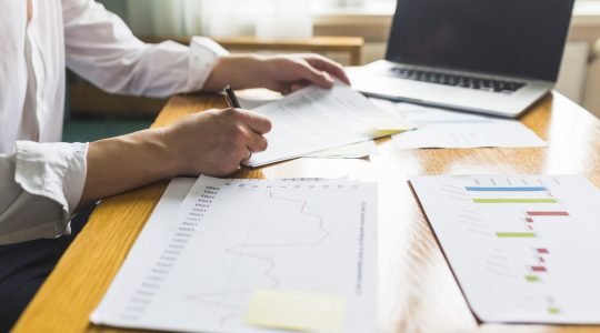 contrato-de-firma-de-mano-del-empresario-sobre-escritorio-de-madera